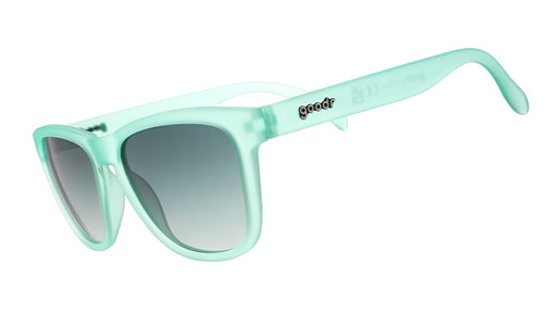 Three-quarter angle view of translucent mint green wayfarer-shaped sunglasses with green gradient lenses.
