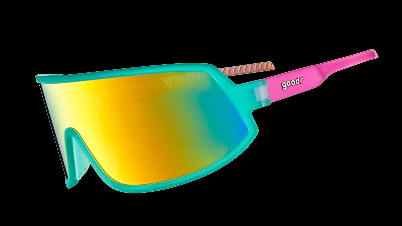 Three-quarter angle view of teal and pink wraparound sunglasses with a single teal lens.