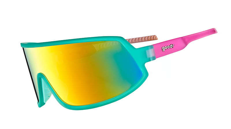 Three-quarter angle view of teal and pink wraparound sunglasses with a single teal lens.
