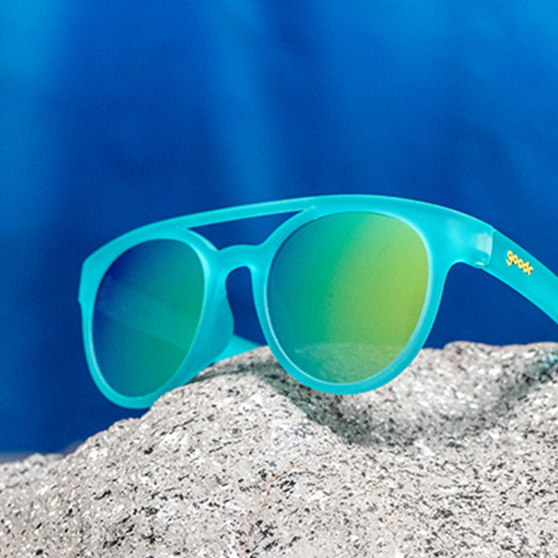 Three-quarter angle view of aqua blue double bridge sunglasses with round reflective aqua lenses.