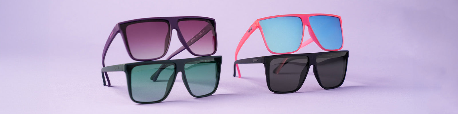 Four pairs of colorful goodr sunglasses with a pastel background.