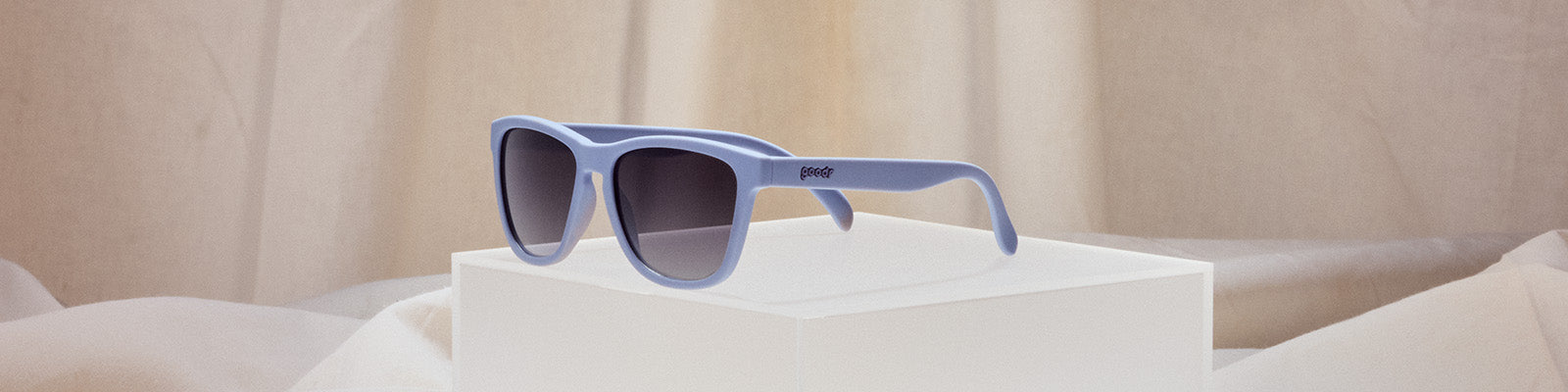 Light blue goodr sunglasses on a white block.