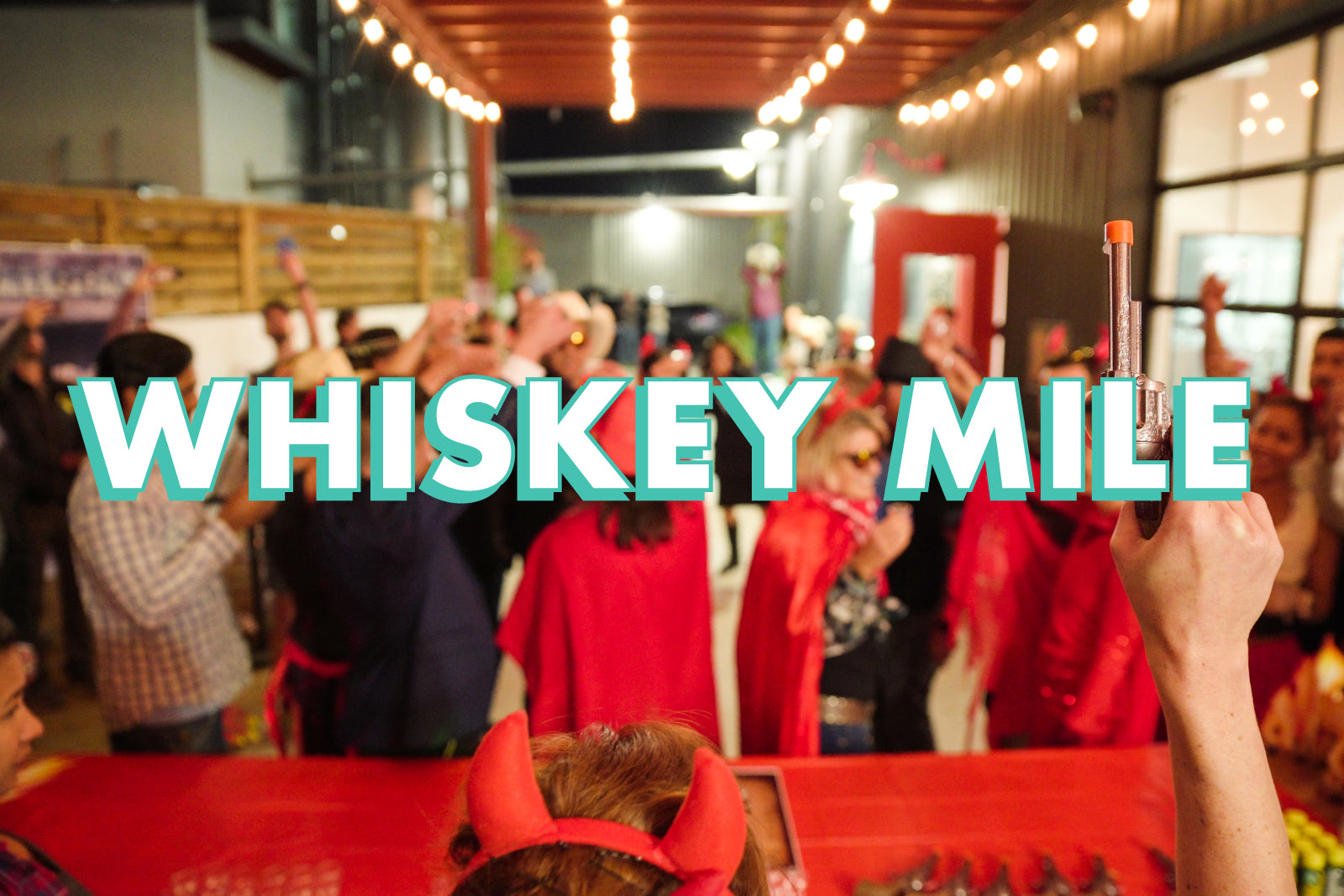 Crowd at an event with "Whiskey Mile" text overlay.
