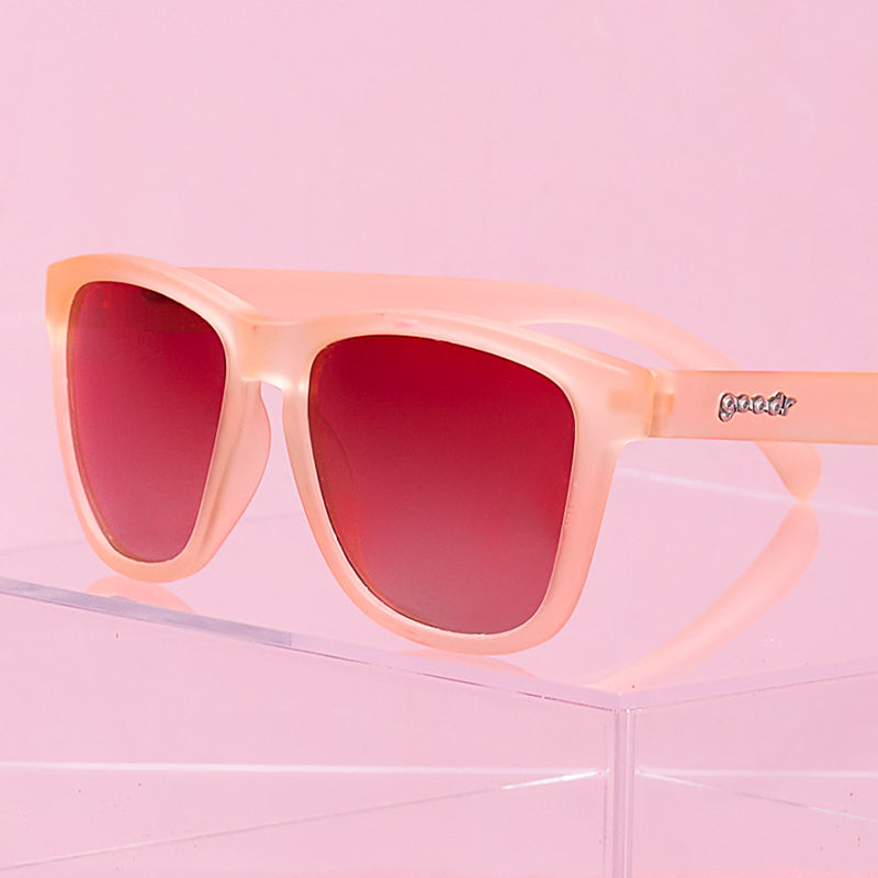 Three-quarter angle view of blush pink sunglasses with square-shaped rose gradient lenses.