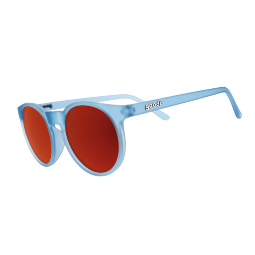 Three-quarter angle view of dusty blue Circle G sunglasses with red reflective lenses on a white background.