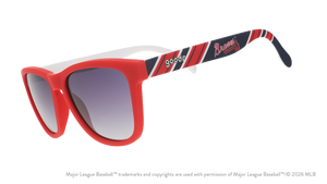 Three-quarter angle view of red, white, and navy Braves sunglasses featuring the script and tomahawk logo on the arm.