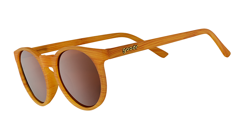 Three-quarter angle view of sunglasses with brown wood grain patterned circle frames, non-reflective round brown lenses.