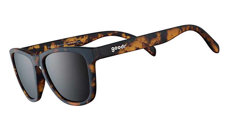 Three-quarter angle view of square brown tortoiseshell sunglasses with brown non-reflective lenses on a white background. 