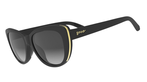 Three-quarter angle view of black cat-eye frames with gold trim and black gradient lenses.