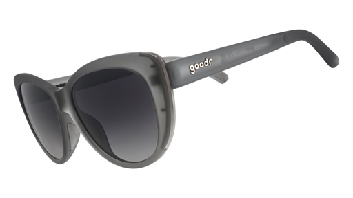 Three-quarter angle view of translucent gray cat-eye sunglasses with black gradient lenses.
