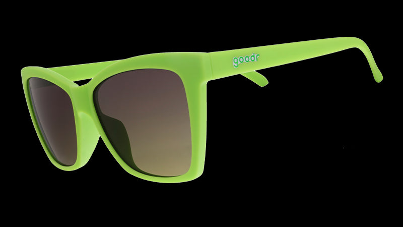 Three-quarter angle view of lime green angled cat-eye sunglasses with non-reflective black gradient lenses.