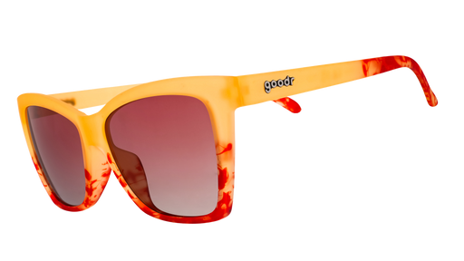 Three-quarter angle view of translucent yellow-orange sunglasses with red hand-painted whirls & rose ocean gradient lenses.
