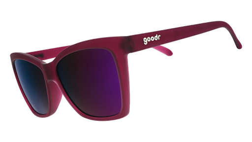 Three-quarter angle view of a pair of translucent red violet angular cat-eye sunglasses with reflective purple lenses.