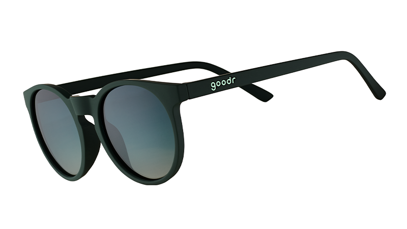 Three-quarter angle view of dark green round sunglasses with circle-shaped green gradient lenses.