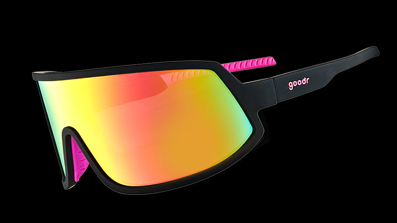 Three-quarter angle view of wraparound sunglasses with black frames with hot pink inner silicone grips, and a big pink lens. 