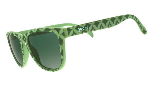 Three-quarter angle view of a pair of green-tile print sunglasses with dark green gradient lenses.