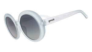 Three-quarter angle view of oversized round sunglasses with translucent blue frames and silver reflective gradient lenses.