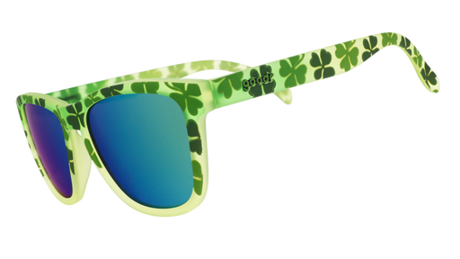 Three-quarter angle view of green shamrock print sunglasses w/ green+gold reflective lenses tilted down.