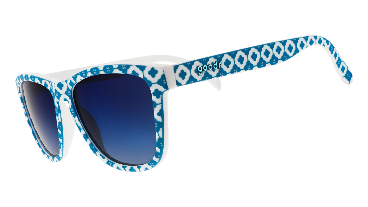 Three-quarter angle view of a pair of blue-and-white tile-print sunglasses with blue gradient lenses.