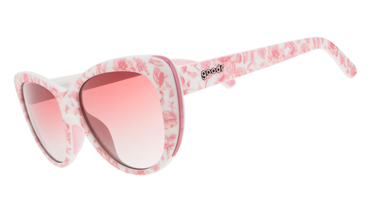 Three-quarter angle view of pink and white cat-eye sunglasses with a floral toile pattern and rose gradient lenses.