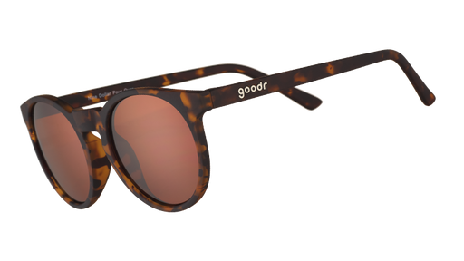 Three-quarter angle view of round brown tortoiseshell sunglasses with non-reflective brown circle-shaped lenses.