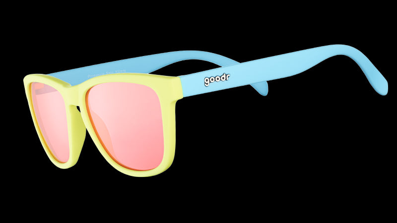 Three-quarter angle view of pastel blue and yellow sunglasses with square-shaped rose-tinted lenses.