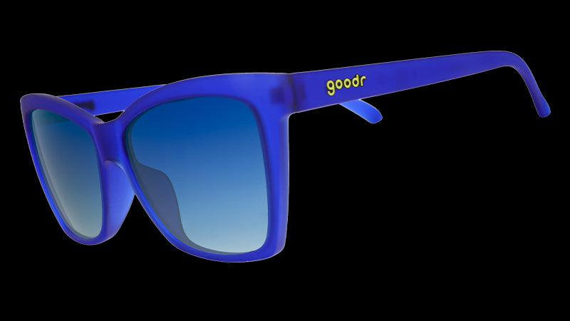 Three-quarter angle view of blue angled cat-eye sunglasses with blue gradient lenses.