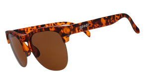 Three-quarter angle view of brown tortoiseshell half-rim sunglasses with brown non-reflective lenses.