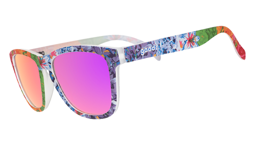 Three-quarter angle view of colorful floral print goodr sunglasses with purple reflective lenses.
