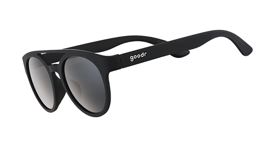 Three-quarter angle view of black round sunglasses with a double bridge and circle-shaped black non-reflective lenses.