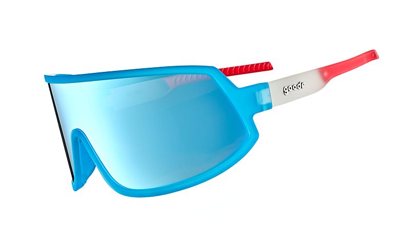 Three-quarter angle view of bright red, white, and blue wraparound sunglasses with a single blue lens.