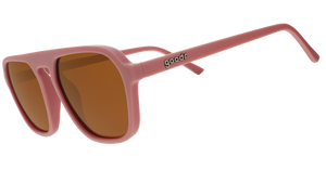 A pair of dusty rose pink goodr sunglasses with muted orange lenses on a white background.
