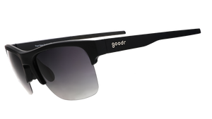 Three-quarter angle view of black half-rim sunglasses with a dual-lens wrap and polarized black gradient lenses and black silicone grips on the inner right arm.