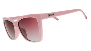 A pair of cat-eye sunglasses with light pink frames and rosy lenses.