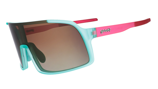 Three-quarter angle view of teal wrap sunglasses with pink arms and amber gradient lenses.