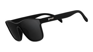 Three-quarter angle view of futuristic-looking black sunglasses with a non-reflective black flat single lens.