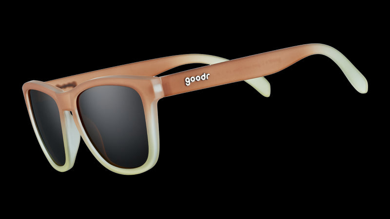 Three-quarter angle view of square-shaped sunglasses with brown-to-white gradient frames and brown, non-reflective lenses.