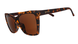 Three-quarter angle view of brown tortoiseshell angled cat-eye sunglasses with non-reflective brown lenses.