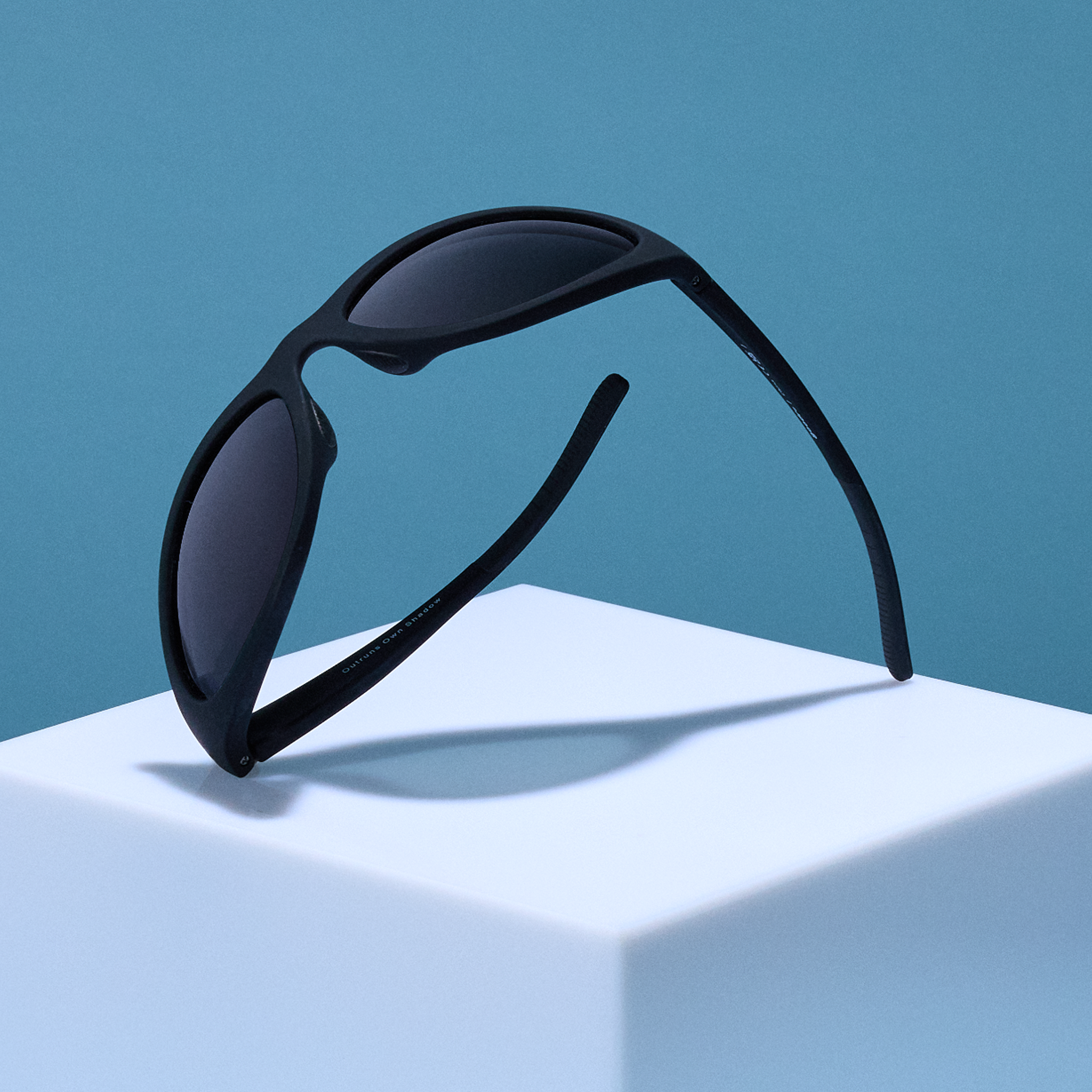 A semi-folded display of black wraparound sunglasses with black non-reflective lenses.