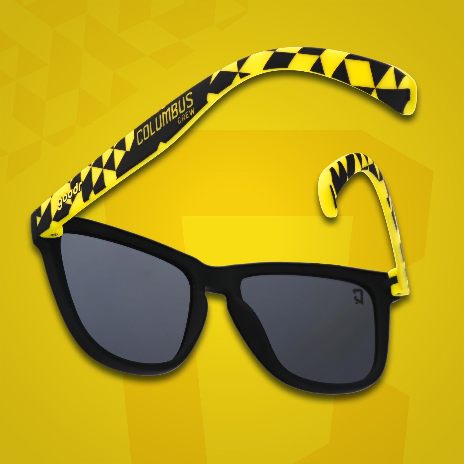 Three-quarter angle back view of MLS Columbus Crew shades on a yellow background. Black+yellow frames. Black lenses.
