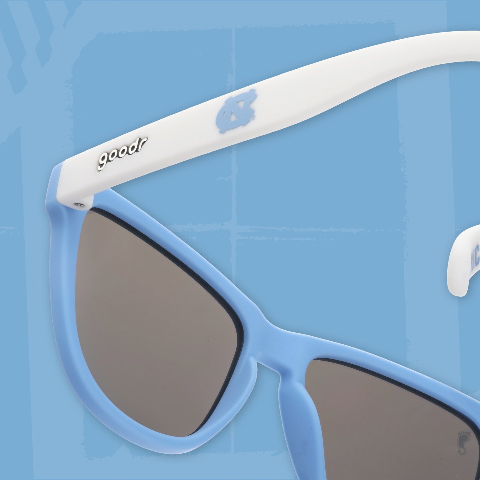 Close-up back view of Carolina blue and white sunglasses featuring ice blue reflective lenses and the UNC logo.