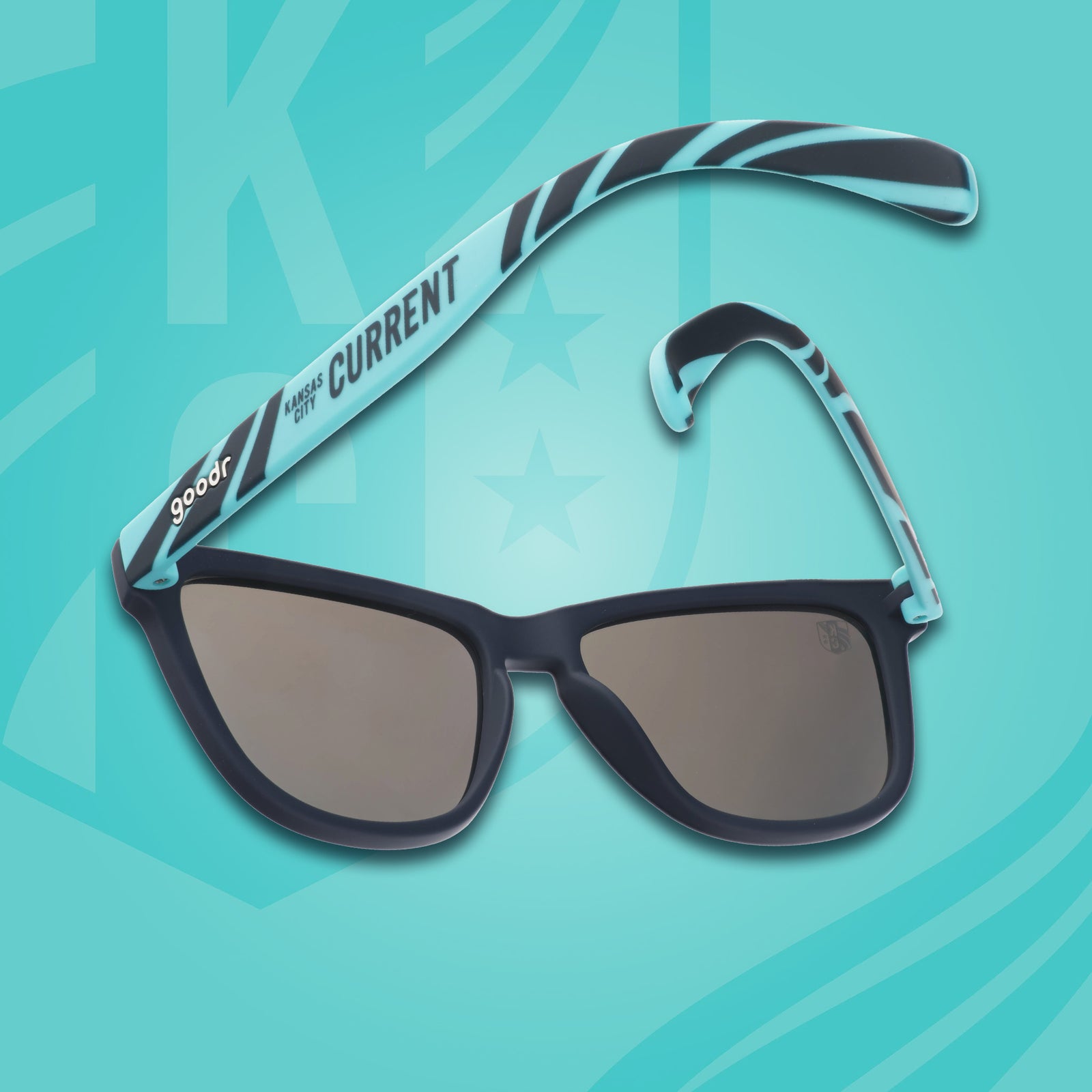 Back view of teal and storm blue sunglasses with a river current pattern, teal lenses, and the Kansas City Current logo.