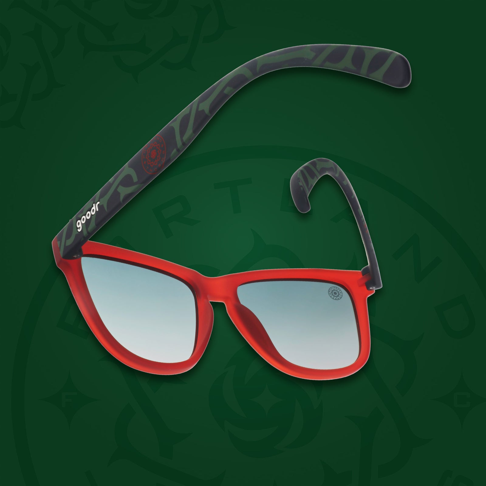 Back view of red & black frames with a green thorn pattern, green gradient lenses, and the Portland Thorns logo on a green background.