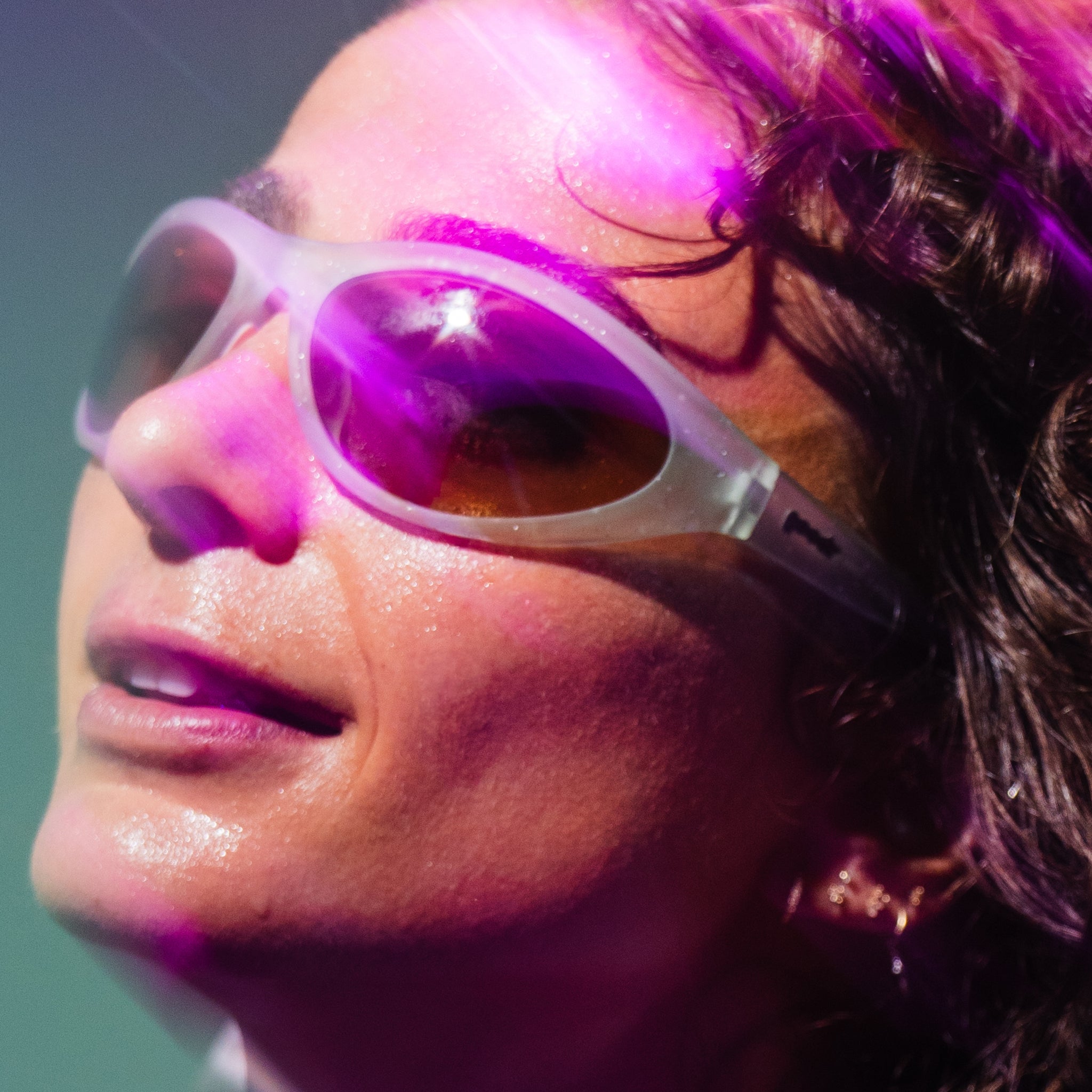 Close-up profile shot of Alexi Pappas rockin' a pair of her signature Bug Gs, bathed in hot pink neon light