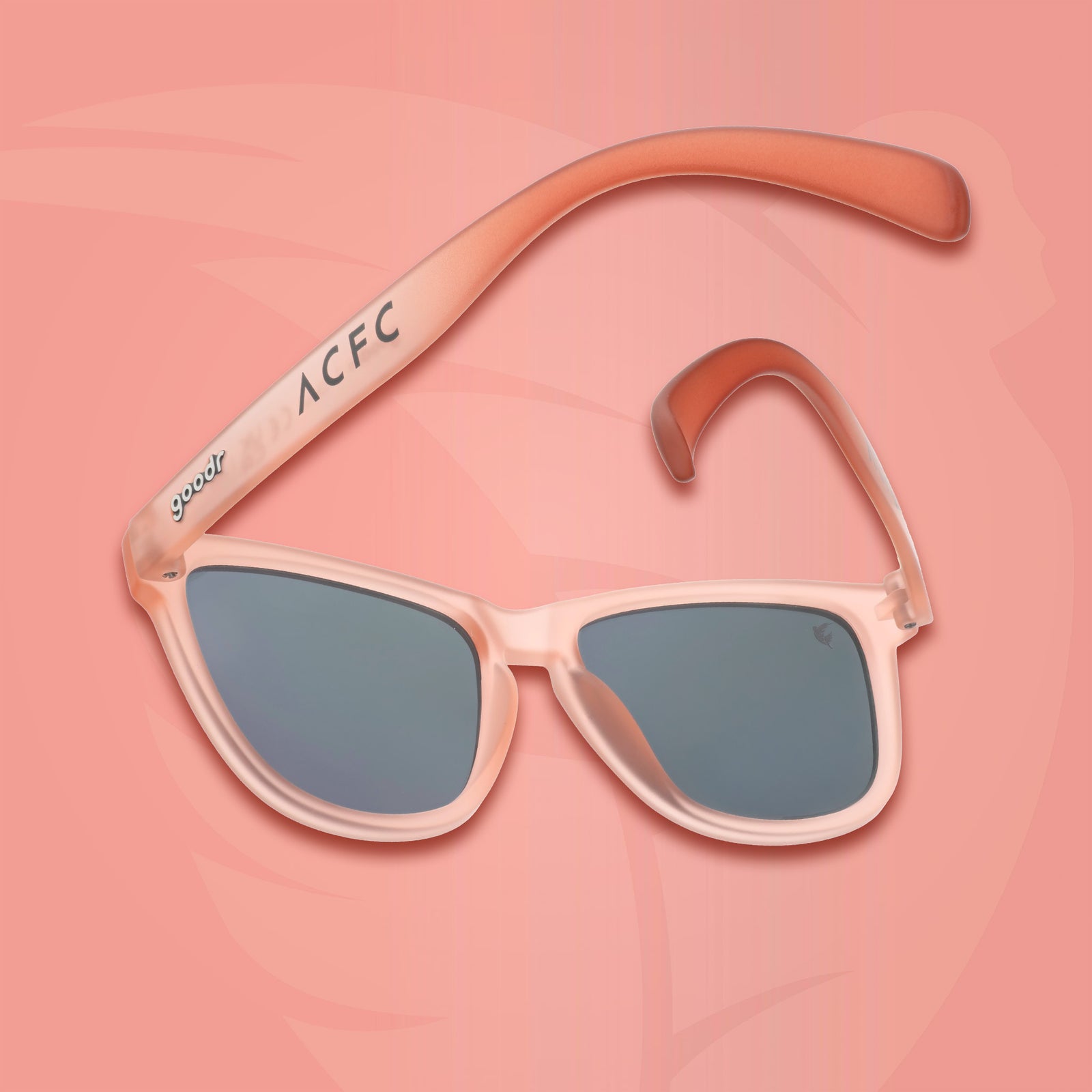 Back view of translucent pink sol rosa sunglasses with an ACFC logo on a pink background.