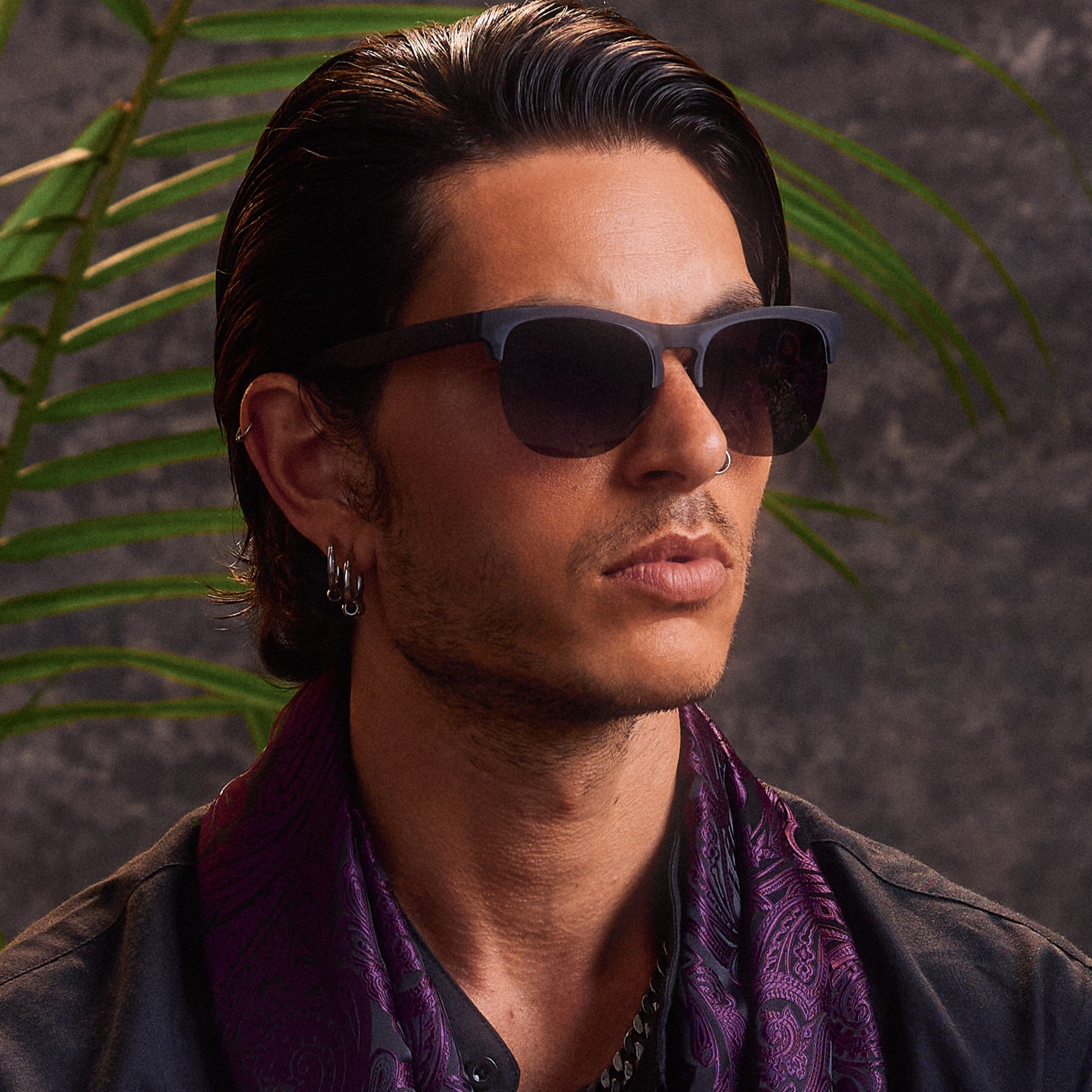 Side profile of a man posing while wearing gray translucent half-rim sunglasses featuring gradient gray lenses.