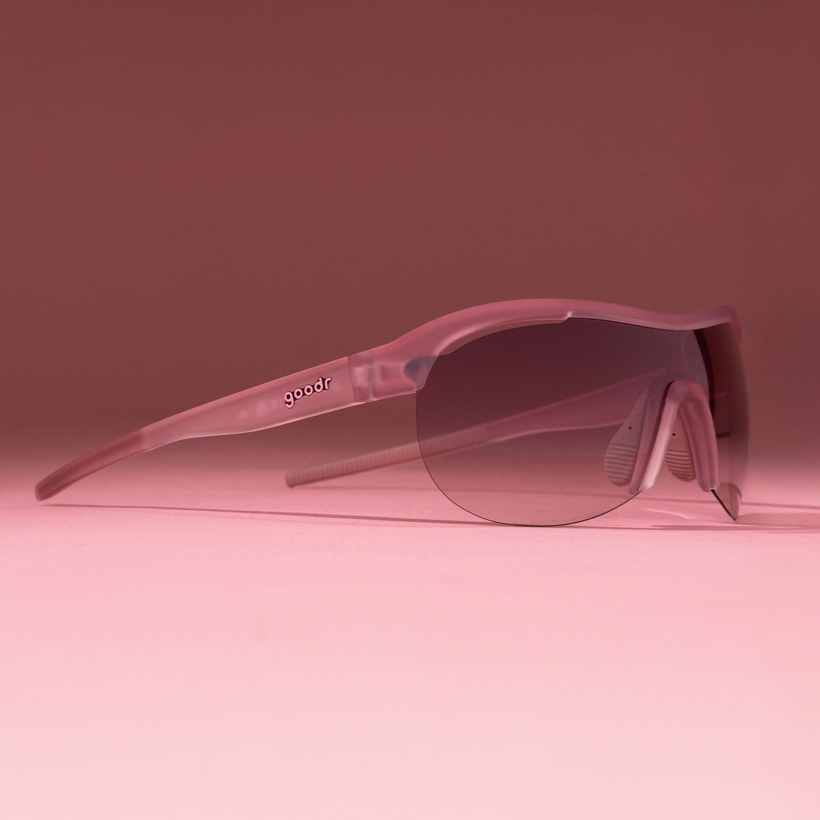 Right three-quarter angle view of translucent purple wrap shield sunglasses with gradient purple lenses on a tabletop.