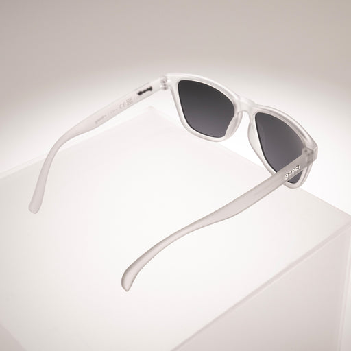 Three-quarter view of clear sunglasses with black non-reflective lenses from behind, showcasing the open arms.