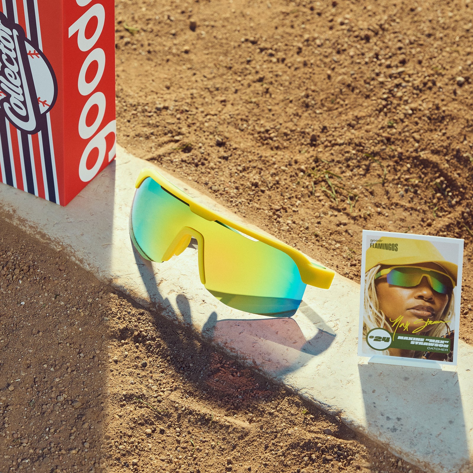 Front view of yellow + green shades w/ green yellow reflective lenses, custom packaging & trading card on a ballfield.