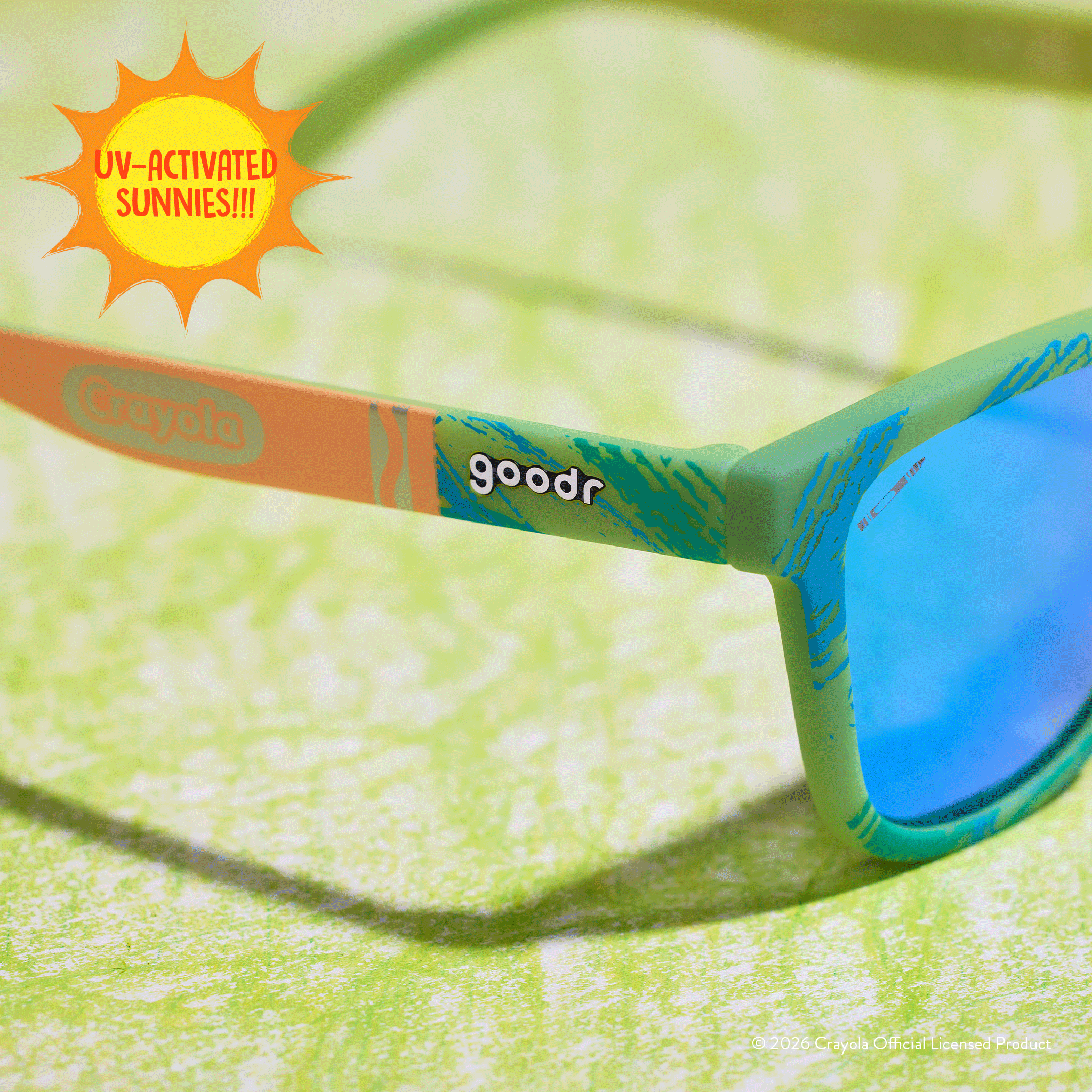 Close-up side view of Crayola goodr UV-activated Confetti Colors sunglasses with light blue reflective lenses.